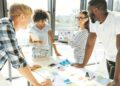 Trace the tendency. Cheerful enthusiastic young people discussing their business project and working together while expressing their ideas