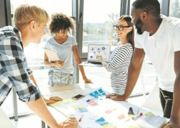 Trace the tendency. Cheerful enthusiastic young people discussing their business project and working together while expressing their ideas