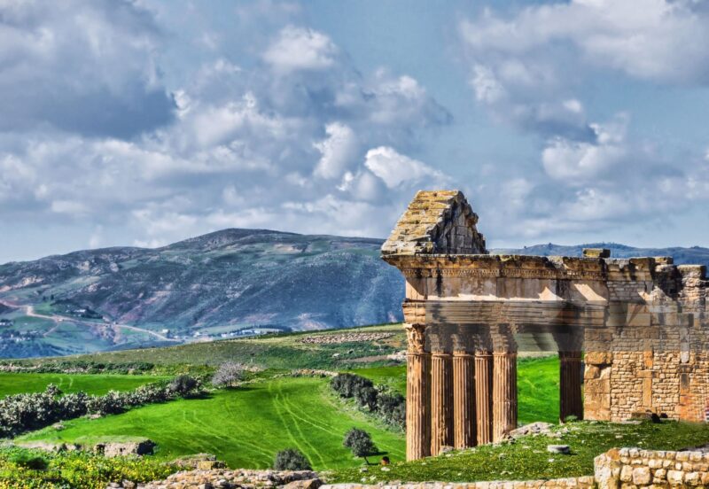 The archaeological site of Thugga/Dougga is located in the North-west region of Tunisia, perched on the summit of a hill at an altitude of 571 m, dominating the fertile valley of Oued Khalled. The impressive ruins give an idea of the resources of a Romanised Numidian town.